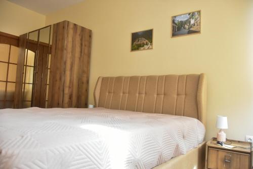 Un dormitorio con una cama blanca y un espejo. en Trimaya apartment - comfort in the top city center, en Varna