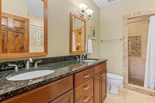 a bathroom with two sinks and a toilet at Croatan Surf Club by KEES Vacations in Kill Devil Hills