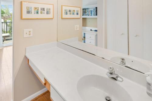 a white bathroom with a sink and a mirror at Scarborough Village - 245 Country Club Dr, Unit #608 in Rehoboth Beach