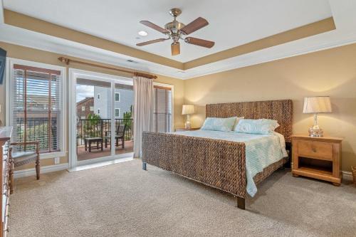 a bedroom with a bed and a balcony at Croatan Surf Club by KEES Vacations in Kill Devil Hills