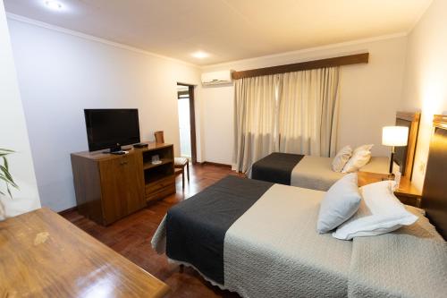 a hotel room with two beds and a flat screen tv at Terrazas Vista Verde in Asuncion