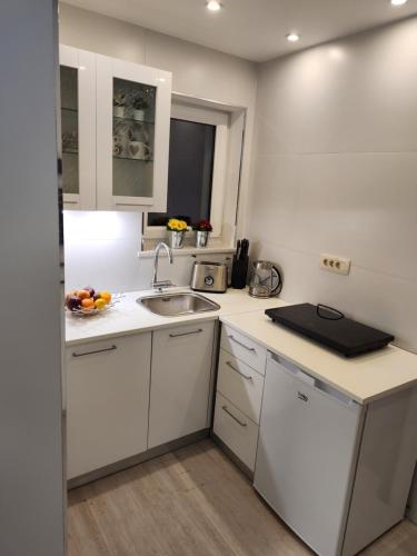 a kitchen with white cabinets and a sink at Vila Rajska ptica in Bled