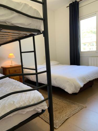 a bedroom with two bunk beds and a window at Belmont 2/2 in L'Estartit