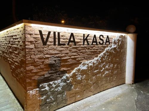a sign on a brick wall with the words vaja xasia at Villa Kasa in Durrës