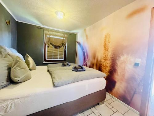 ein Schlafzimmer mit einem Bett, einem Fenster und einem Bettvisor in der Unterkunft kleine Seemöwe in Zingst