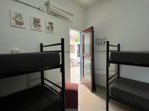 Zimmer mit 3 Etagenbetten und einem Eingang in der Unterkunft Link Cordoba Hostel in Cordoba