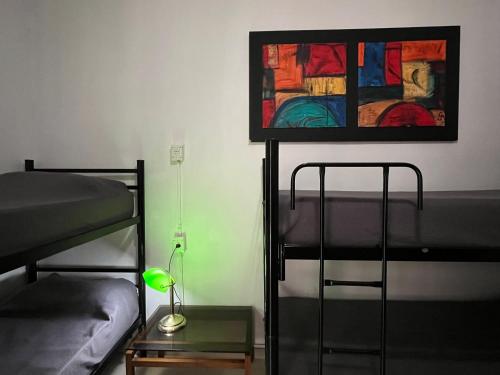Zimmer mit 2 Etagenbetten und einem Gemälde an der Wand in der Unterkunft Link Cordoba Hostel in Cordoba