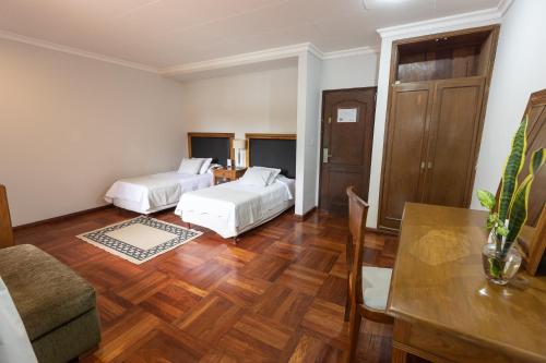 a living room with two beds and a table at Terrazas Vista Verde in Asuncion