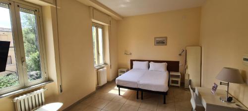 a bedroom with a bed and a desk and a window at Villa Riari Garden in Rome