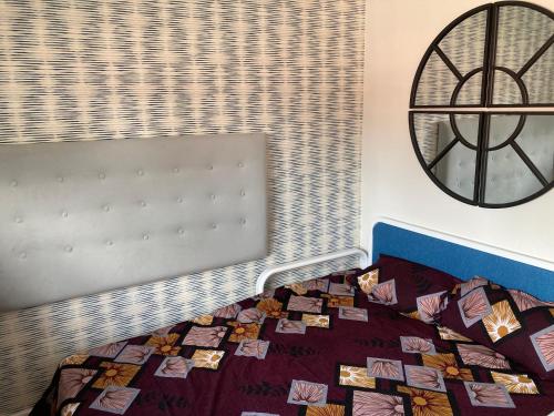 een slaapkamer met een bed en een klok aan de muur bij Chandra House in Swindon