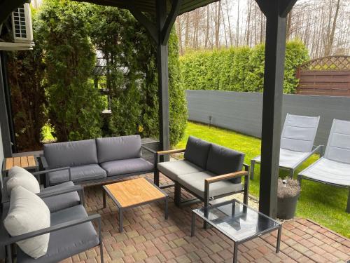 patio z kanapą, krzesłami i stołem w obiekcie Dom na Polanie w Boszkowie