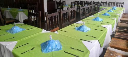 a row of green tables with blue napkins on them at Hotel MAXIRUMA - Villa TAMAUKA in Iza