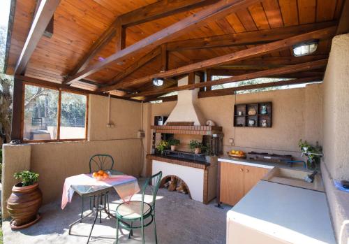 a kitchen with a stove and a table with chairs at Elichrison Studios in Lygia