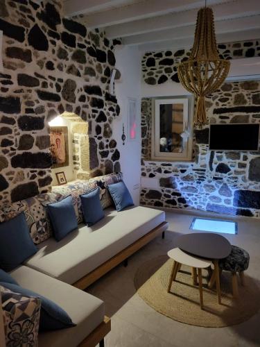 a living room with a couch and a stone wall at Spiliani View in Mandrakion