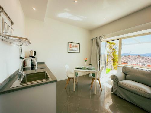 a kitchen and living room with a couch and a table at Villa Ada Olbia in Olbia