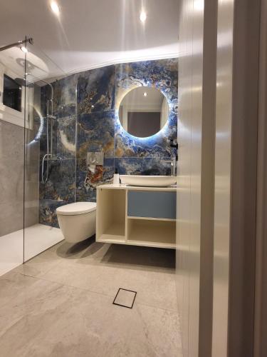 a bathroom with a toilet and a sink and a mirror at Spiliani View in Mandrakion