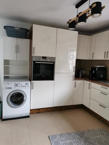 a kitchen with white cabinets and a washing machine at Hübsches Haus in Emden