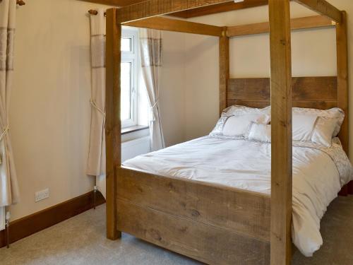 - une chambre avec des lits superposés en bois et des draps blancs dans l'établissement Little Hoot, à Baslow