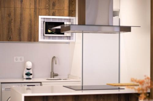 a kitchen with a sink and a microwave at Apartamentos Fleming in Albacete