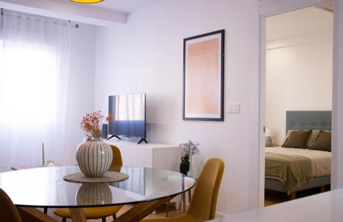 een witte woonkamer met een tafel en een bed bij Apartamentos Fleming in Albacete