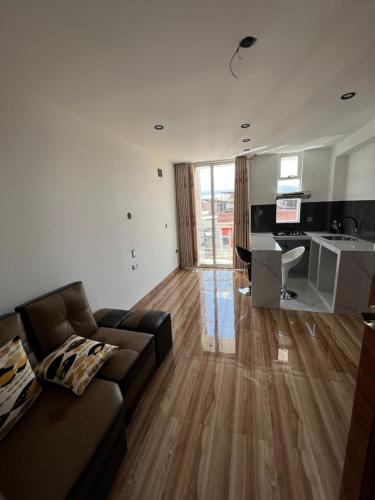 a living room with a couch and a kitchen at Hotel SOGU TOWER in Ayacucho