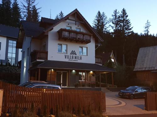 a building with a sign that reads village mutual at VILLA MILA Apartamenty in Karpacz