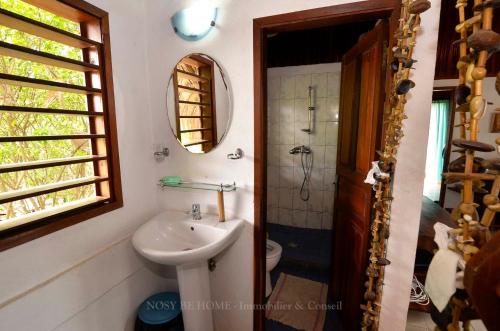 a bathroom with a sink and a toilet and a mirror at L'antafa in Ambondrona