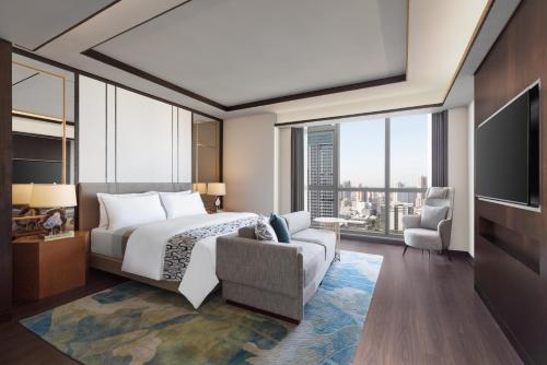 a hotel room with a bed and a tv at The Westin Manila in Manila