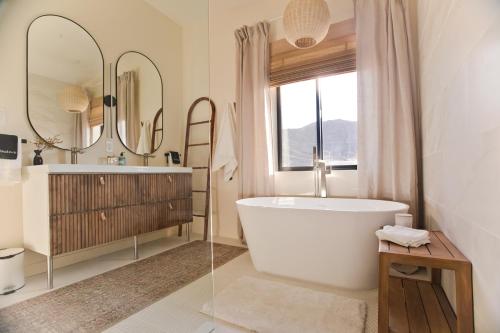 y baño con bañera, lavabo y espejo. en Modern Desert Dream - NEW BUILD en Twentynine Palms