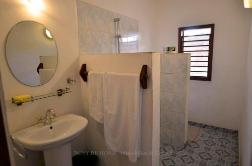 a bathroom with a sink and a mirror at L'antafa in Ambondrona