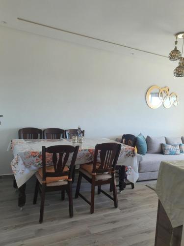 a dining room with a table and chairs and a couch at HEAVEN BEACH in Sidi Rahal