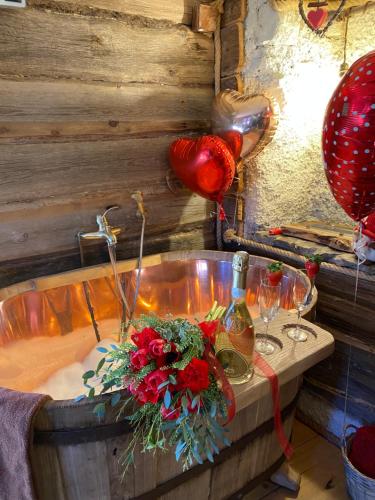 una vasca da bagno con bouquet di fiori e bicchieri da vino di Il Roccolino a Valsecca