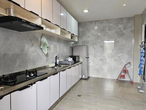a kitchen with white cabinets and a stainless steel refrigerator at Spacious 5-bedroom, 4-bath townhouse in Legazpi City in Legazpi