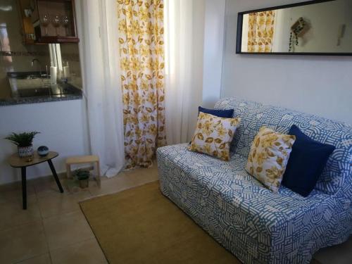 een woonkamer met een blauwe bank met kussens bij ACOGEDOR ATICO CON TERRAZA EN SAN CRISTOBAL DE LA LAGUNA in La Laguna