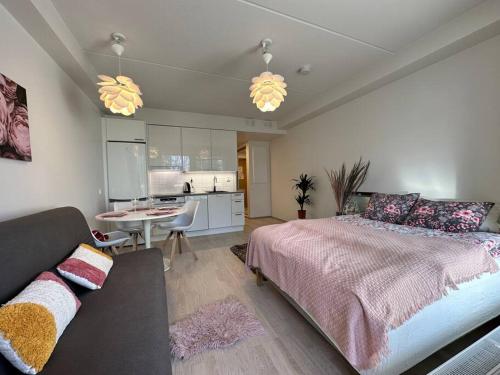 a bedroom with a bed and a table and a kitchen at studio Finnoo Espoo next to metro, easy to reach Helsinki and Otaniemi, Aalto in Espoo