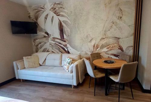 ein Wohnzimmer mit einem Sofa und einem Tisch in der Unterkunft Apartament Aqua 27 Premium nearby Beach in Świnoujście