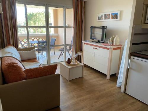 a living room with a couch and a television at CAP ESTEREL AGAY SAINT RAPHAEL VUE MER Studio 4 personnes chez Evelyne in Saint-Raphaël