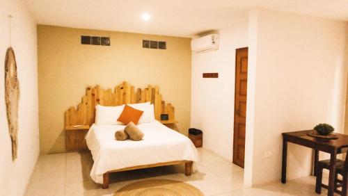 a bedroom with a bed with a wooden headboard at Mezcal Hotel in Cancún