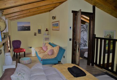 a living room with a bed and a chair at La Casa del Campillo in Baltanás