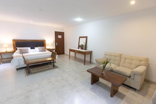 a bedroom with a bed and a couch and a table at Terrazas Vista Verde in Asuncion