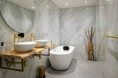 een badkamer met 2 wastafels en een groot bad bij In de Mid - Prachtige appartementen in hartje Joure in Joure