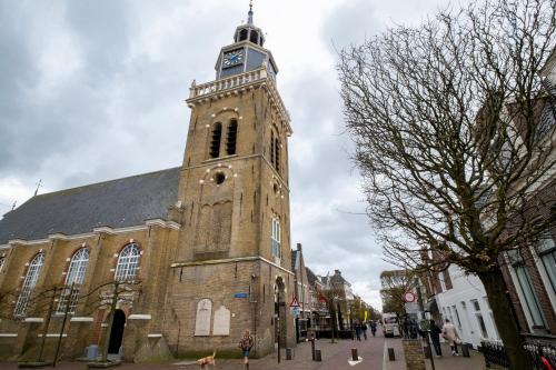 a church with a tower with a clock on it at In de Mid - Prachtige appartementen in hartje Joure in Joure