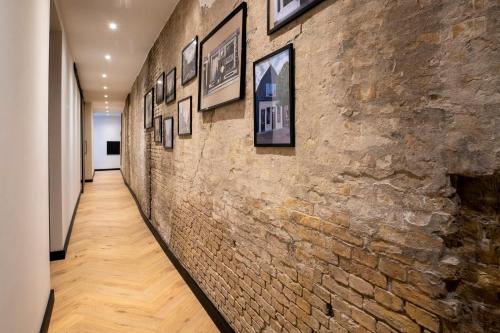 a hallway with a brick wall with pictures on it at In de Mid - Prachtige appartementen in hartje Joure in Joure