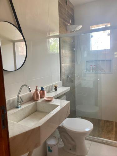 a bathroom with a sink and a toilet and a mirror at Casa Villa Serrano in Lençóis