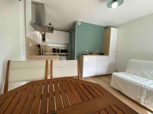 ein Wohnzimmer mit einem Sofa und einer Küche in der Unterkunft Hourtin Port - Maison rénovée avec jardin à 150 m du lac in Hourtin