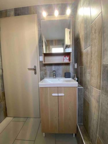 une petite salle de bain avec un lavabo et un miroir dans l'établissement Hourtin Port - Maison rénovée avec jardin à 150 m du lac, à Hourtin