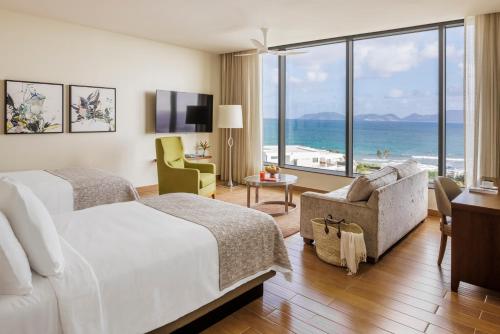 a hotel room with a bed and a view of the ocean at Aurora Anguilla Resort & Golf Club in Rendezvous Beach