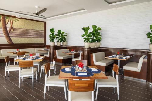 a restaurant with tables and chairs and plants at Aurora Anguilla Resort & Golf Club in Rendezvous Beach
