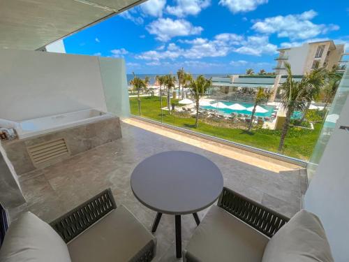a room with a table and chairs and a large window at Haven Riviera Cancun - All Inclusive - Adults Only in Cancún