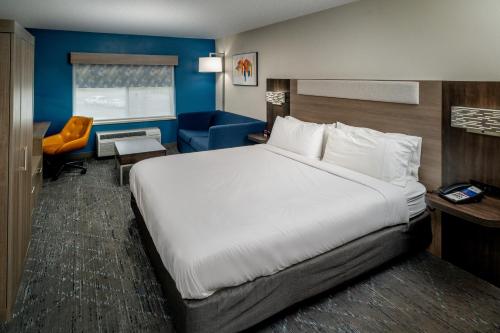 a hotel room with a large bed and a chair at Holiday Inn Express - Charleston/Kanawha City, an IHG Hotel in Charleston